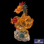 SWAROVSKI TUTELARY SPIRIT - Auspicious Dragon (Dragão Auspicioso). Altamente detalhado e de edição limitada, lançado originalmente com foco no mercado asiático. Corpo em cristal facetado na cor dourada / amarela, detalhes vibrantes nas cores Light Siam (vermelho) e Blue Zircon (azul-esverdeado), segurando uma esfera vermelha e posicionado sobre uma base de cristal transparente que simula nuvens estilizadas. Atualmente encontra-se descontinuado (retirado de linha) pela Swarovski, o que eleva seu valor entre colecionadores em plataformas de leilão e revenda internacional. 19 x 20 cm.