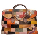 FRANCESCA GIOBI - Maxi Bolsa de Viagem assinada pela renomada designer brasileira Francesca Giobbi. Confeccionada artesanalmente em couro legítimo texturizado (com texturas que imitam peles exóticas, como cobra e crocodilo). Trabalho rico em patchwork, unindo retalhos multicoloridos com acabamento em pesponto. Apresenta aplicações em relevo de pássaros estilizados, alça de mão dupla estruturada e fecho central giratório na cor dourada. 55 x 61 cm.