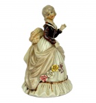 SANKYO - Estatueta em cerâmica retratando Senhora Colonial com caixa de música acoplada, med. 20cm de altura. Apresenta bicado na barra da saia. 
