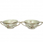 WARWICK CHINA – Par de Consomê em porcelana inglesa na cor branca com detalhes florais e frisos dourados, med. 16cm entre alças e 11,5cm de diâmetro.  Apresenta bicados na borda.