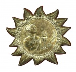 Placa de mesa em metal colado em madeira no formato de resplendor solar com imagem central de criança na Primeira Comunhão, med. 9,5cm de diâmetro.