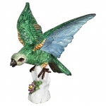 Pássaro de asas abertas pousado sobre tronco com flores esmaltada e tons vidrante de verde, azul, ma