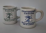 COLECIONISMO - Duas canecas em cerâmica com logo " Churrascaria Gaúcha" . Medida : 8x11 cm.