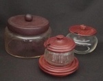 Lote com Três potes em vidro, com tampa de madeira, sendo : Dois açucareiro e uma biscoiteira .Maior medindo : 13x13x11 cm