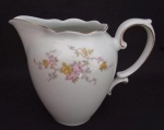 RENNER - Belíssima Leiteira em porcelana , com decoração floral e filetagem dourada . Medindo : 17x10x14 cm .