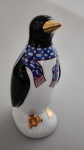 Escultura representando pinguim. Escultura em preto e branco em detalhes com cachecol em tom azul e amarelo. Medindo 14 cm de altura.Obs : Existe outros modelos e tamanhos no leilão .