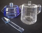 Leiteira em acrílico translúcido; acompanha açucareiro do mesmo material na cor azul rei. Medindo 10 cm de altura o mais alto. Novos.