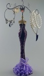 Belíssimo suporte para jóias/bijouterias, com grandes proporções representando manequim com vestimenta de festa na cor lilas e detalhes em preto e dourado. Não Acompanha as joias , sao ilustrativas  . Medindo 34 cm de altura no total.