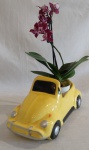 Floreira representando Fusca em faiança na cor amarela vitrificada. Medindo 27 x 10  x 10 cm.