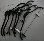 Lote com seis cabides na cor preta acabamento em inox com presilhas .