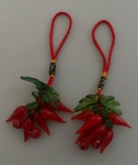 Dois pingentes em linha de seda, decorado com pimentas em vidro soprado na cor vermelha com folhas na cor verde. Medindo no total o pingente 9 cm de comprimento