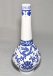 CHINA, PERÍODO REPUBLICANO - SÉC. XX - Bottle vase ou vaso de gargalo comprido em porcelana chinesa azul e branca, pasta mole, pintado a mão com dragões de cinco garras perseguindo a pérola flamejante sobre um fundo de folhagens e flores de lótus estilizadas, ladeado por um padrão de gregas (leiwen) na boca e ruyi no ombro. Marca azul no fundo. Med. 31,5 cm
