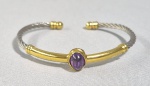 Bracelete em aço e metal folheado a ouro com cabuchon de Ametista natural. Ajustável.