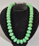 Colar com grandes contas facetadas em jade verde. Fecho e arremates em prata contrastada. Med. 48 cm