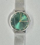 TOMMIE HILFIGER - Tommy Hilfiger Pippa 1782762, um modelo feminino com mostrador verde esmeralda e bracelete de malha de aço prateada. Zalando.pt +1Design e Mostrador: Caixa redonda em aço inoxidável de 35 mm com acabamento verde brilhante, marcadores de horas minimalistas e ponteiros dourados.Bracelete: Pulseira de malha milanesa (mesh) em aço prateado com fecho ajustável. Funcionando. Bateria nova. necessita apenas limpeza do vidro. Med.
