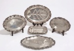 Barbour Silver Company - Séc.XIX - (BSCEP) - ativa entre 1892-1930.  Aparelho para servir em silverplate inglês, bordas recortadas e decoradas com guirlandas de Parreiras e uvas. Composto por 6 travessas. Medida maior: 48 e menor 30 cm Alguns desgastes.  VER COTAÇÕES --- https://www.1stdibs.com/furniture/dining-entertaining/platters-serveware/barbour-co-bscep-antique-victorian-ornate-silver-plate-repousse-oval-platter/id-f_31272792/ ------- https://sterlingflatwarefashions.com/silvermiths/barbour-silver-co/#::text=The%20BSC%20mark%20continued%20to,silverplated%20wares%20are%20marked%20BSCEP.