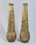 ART DECO - Anos 30 - Par de vasos altos em metal dourado com pátina escura, flores e folhagens em relevo realçado em douração. Med. 41 cm