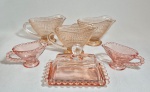 Conjunto com 6 peças em vidro salmão lapidado, sendo 5 molheiras e uma mantegueira. Med. 10 x 5 x 5, 13x08x08 cm e 14 x 08 x 06 cm