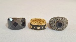 Lote com 3 aneis em materiais diversos, ornados com pedrarias negras. Aros: