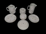 Renner. Conjunto de chá em porcelana esmaltada, decorado com flores policroma, composto de bule, leiteira, manteigueira e 5 pratos para sobremesa. Manufatura no verso. Medindo: leiteira; 17,5x15x9,5, bule 11,5x20,5 x15, açucareiro 11,5x9,5 , mangueira 17,5x6 , pratos 17,5 cm.