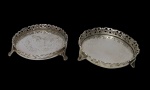 Duas pequenas bandejas redondas, produzidas em metal espessurado a prata, com galeria vazada. Medindo 11,3 cm e 13 cm.