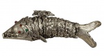 Escultura representando peixe em metal espessurado a prata, com corpo articulado formado por escamas móveis em relevo, cauda estilizada e detalhes ornamentais na cabeça com aplicações coloridas. Medida: 23 cm.