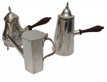 Conjunto com três bules em metal espessurado a prata, com corpos de formatos distintos, todos com alças em madeira. Uma peça apresenta corpo bojudo com caneluras em relevo e pés elevados; outra possui corpo facetado de linhas retas; e a terceira apresenta corpo alto com frisos verticais e tampa ornamentada. Medidas: 6 x 13 x 6,5 cm / 18 x 9,5 x 20 cm / 21 x 9 x 18 cm.