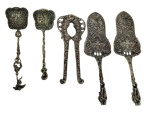 Lote contendo 5 talheres de serviço, produzidos em metal espessurado a prata, com cabos ricamente trabalhados em relevo com motivos florais e arabescos, composto por peças de diferentes formatos para servir. Medidas: 18,3 cm, 15 cm , 22,3 cm  e 16,5 cm.