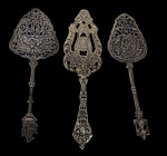 Lote contendo 3 espátulas para servir, produzidas em metal espessurado a prata, com trabalhos vazados e ricos relevos ornamentais em estilo clássico. Medidas: 19,5 cm / 20 cm / 19,5 cm.