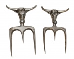 Lote contendo 2 garfos para churrasco, produzidos em metal espessurado a prata, com hastes em formato de cabeça de boi, conferindo caráter temático à composição. Medidas: 8 x 16 cm e 16,8 x 8,5 cm.