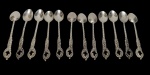 Lote contendo 12 colheres pequenas para chá, produzidas em metal espessurado a prata, com cabos ornamentados em relevo de inspiração floral e vazados decorativos.
