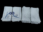 Lote contendo 17 guardanapos de tecido, em dois modelos distintos, sendo parte com bordados florais em azul e parte com delicados bordados vazados em branco sobre branco, com acabamento manual nas bordas.