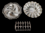 Lote contendo petisqueira, pequeno centro de mesa e porta torradas, produzidos em metal espessurado a prata, com decoração em relevo e bordas trabalhadas. Medidas: 13 x 16 x 8 cm / 19 x 5 cm / 11 x 21 cm.