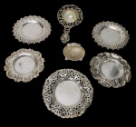 Lote contendo 7 peças diversas, produzidas em metal espessurado a prata, sendo 5 pequenas salvas, 1 porta-joias em formato de concha e 1 espelho de mão. Medidas: 11 cm / 9,5 cm / 10 cm / 11 cm / 5 x 6 x 2 cm / 13 x 8 x 2 cm.