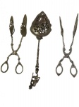 Lote contendo 3 peças para servir, produzidas em metal espessurado a prata, com bojos vazados e ricos detalhes ornamentais em relevo, incluindo 2 pegadores e 1 colher perfurada com cabo decorativo. Medidas: 22 cm, 20 cm e 27 cm.