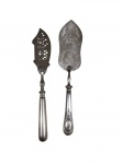 Duas espátulas para bolo, produzidas em metal espessurado a prata, sendo uma da marca Christofle, com cabos de desenho clássico e uma delas com lâmina vazada decorativa. Medidas: 30 cm cada.