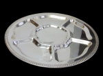 Grande petisqueira giratória produzida em metal espessurado a prata, de formato circular com divisórias internas e compartimento central, borda com acabamento torsadé. Medidas: 47,5 x 7 cm.