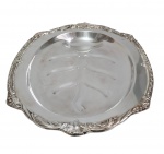 Imponente e grande bandeja de serviço, produzida em metal espessurado a prata, com bordas ricamente ornamentadas em relevo e decorado em baixo-relevo com motivo vegetal estilizado. Medidas: 49,5 x 33 x 4,5 cm.