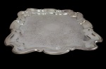 Antiga bandeja, de manufatura inglesa, produzida em metal espessurado a prata, medindo 38,5  x 38,5 cm.