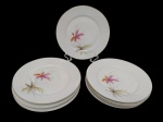Maua - Oito pratos rasos em porcelana, esmaltado  com flores  e friso dourado. Medindo: 24 cm. Apresenta discretos desgastes de uso.