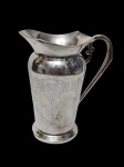 Antiga jarra produzida em metal espessurado a prata, parte central cinzelado. Medindo: 22 cm. Apresenta pequena morsa na base.