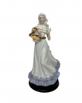 Escultura em porcelana esmaltada representando dama com cesto de flores. Medindo: 14,5 x 12,5 x 28,5 cm.