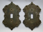 2 (dois) Antigos Espelhos para Interruptor de Luz em Metal; possivelmente Bronze, ricamente cinzelado com desenhos no formato que remete a flor. Raridade. Med.: 15 X 10 cm.