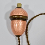 Raro interruptor de campainha em formato de avelã, metal recoberto de esmalte cloisonné, botão e conector em baquelite imitando marfim. França, séc. XIX. Med. 5 cm a parte maior, não testado, no estado.