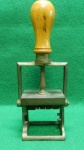 Carimbo datador antigo. Estrutura em metal latão, com pega em madeira. Patina causada por ação do tempo. Em BOM estado. 21,5 A x 9,5 C x 5,5 L.-