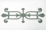 Elemento decorativo em ferro fundido, possivelmente oriundo de gradil, portão ou detalhe arquitetônico, com composição simétrica, volutas, flechas e motivos ornamentais. Apresenta pátina natural do metal e marcas do tempo compatíveis com exposição e antiguidade. Mede: Alt.32cm x Larg.88cm x Prof.2cm .