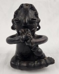 Escultura étnica em barro cozido. Representando figura antropomórfica sentada tocando instrumento musical. Medindo: 20 cm