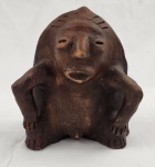 Escultura étnica em barro cozido. Representando figura antropomórfica em posição agachada, com traços estilizados. Medindo: 18 x 14 cm.