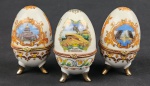 Três caixinhas porta ovos em porcelana esmaltada e policromada, aplicações em metal dourado.