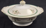 DRAGON CHINA JAPAN. Terrina com tampa em porcelana japonesa, decoração floral e filetes em ouro, com listra verde sobre fundo marfim e branco. Manufatura no verso. Med.: 16 x 26 x 24 cm.